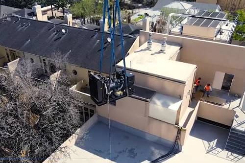 Lifting a generator by crane to the rooftop of ahigh rise condominium